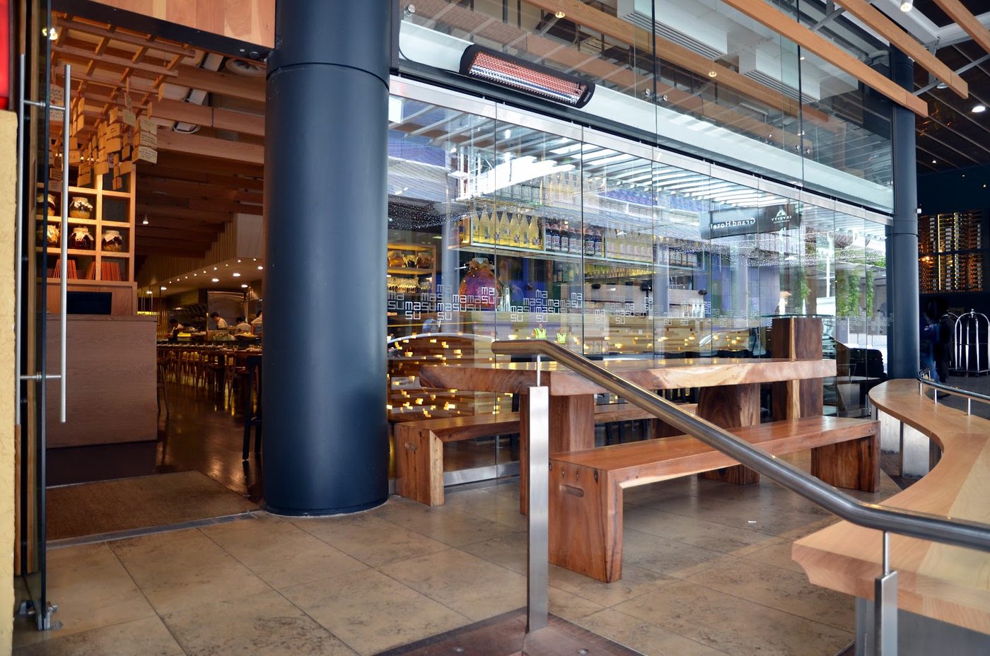 The entrance to MASU, with timber benches and the open kitchen beyond