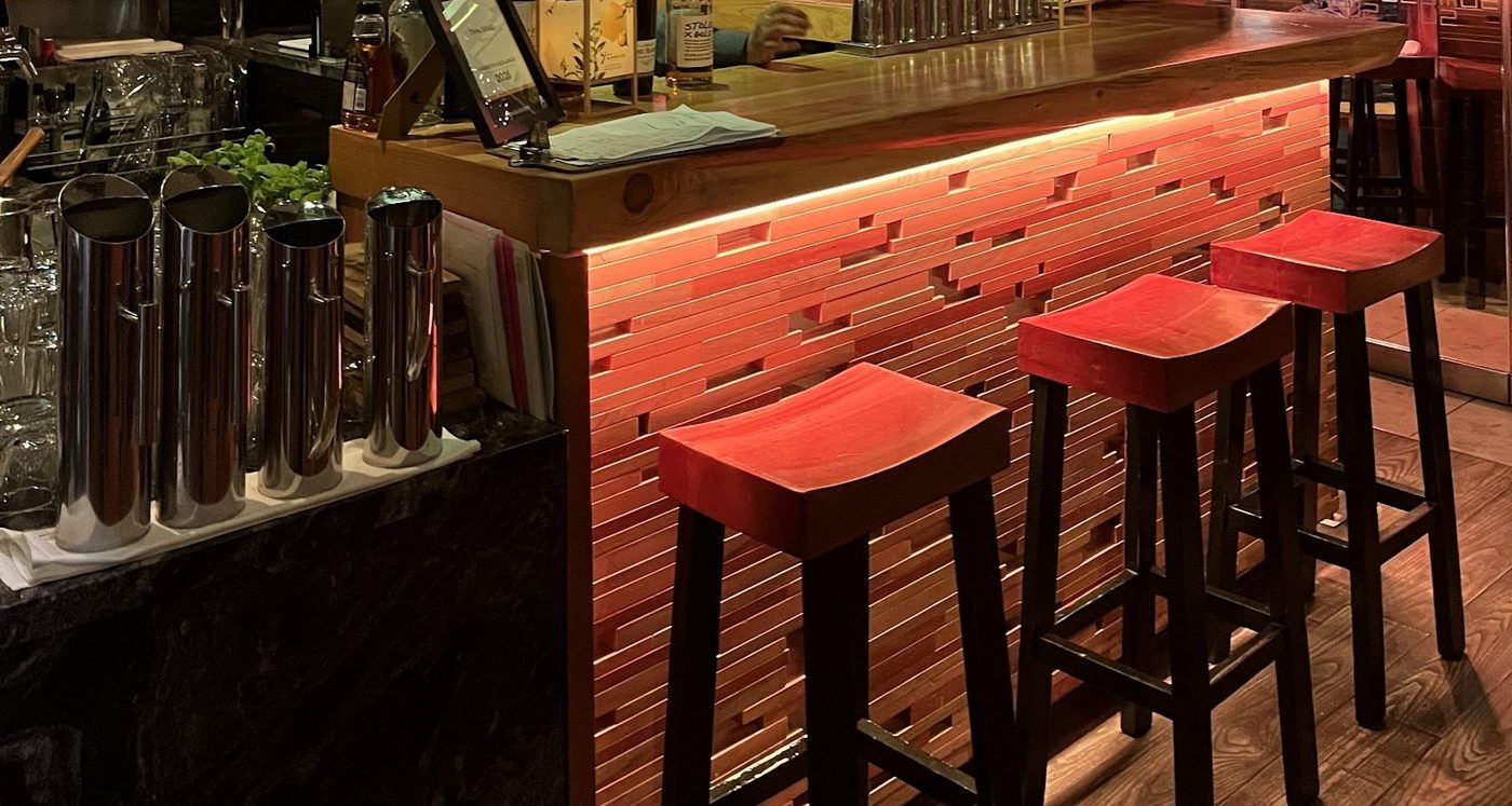 The MASU bar, lit from beneath the counter, with red lacquered stools