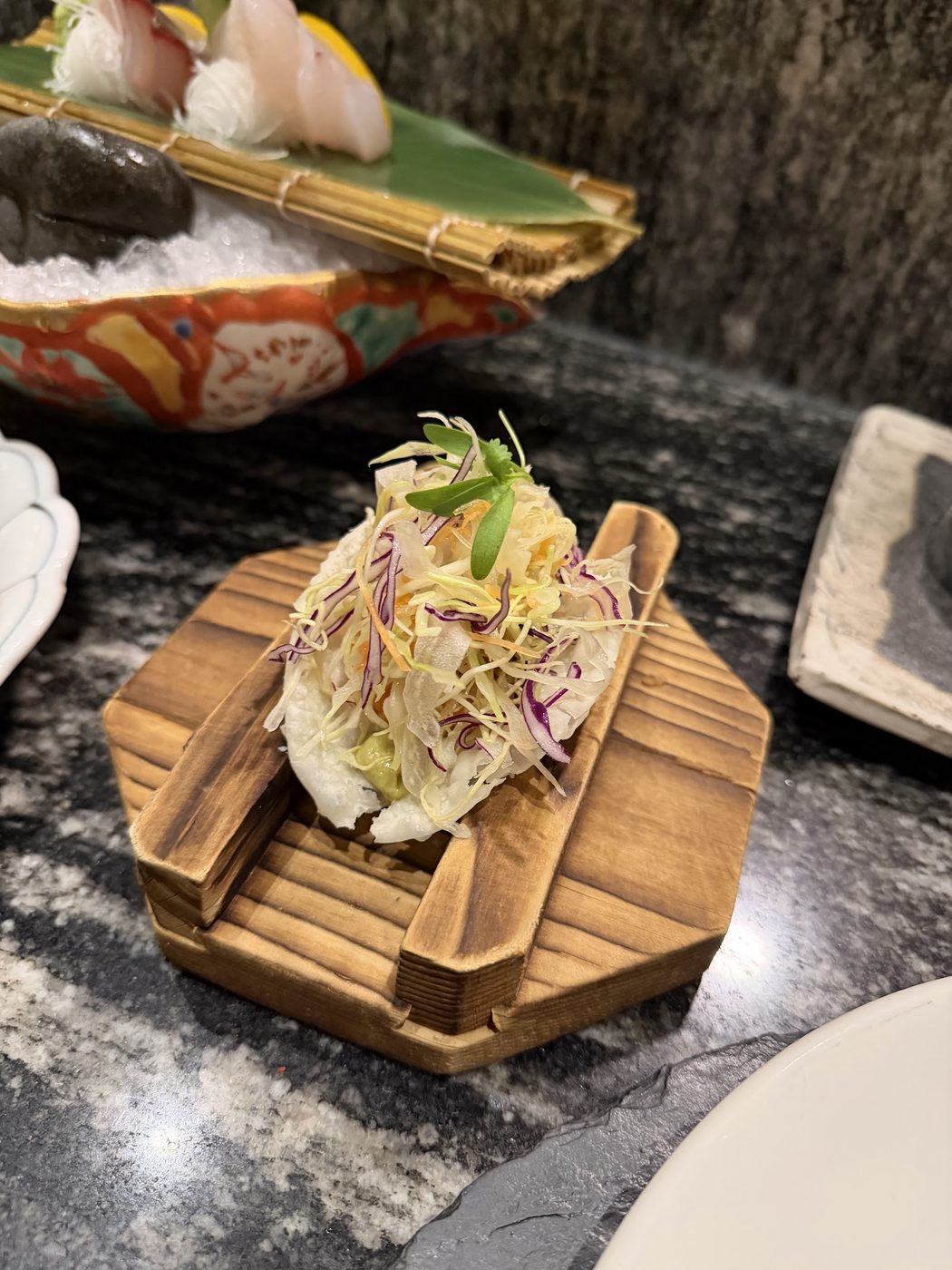 A plated dish served on a wooden board with rice and garnish